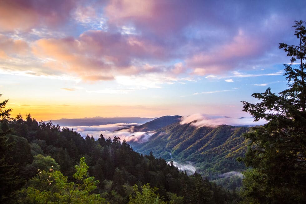 Resort Concierge Escapes Reviews shows a sunset over the Smoky Mountains, supporting Gatlinburg's scenic outdoor travel appeal.